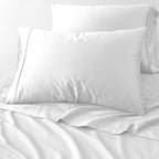 Two white pillows on a white bed