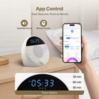 White electronic device with digital display on a wooden surface, held by a hand with a smartphone showing app control features.