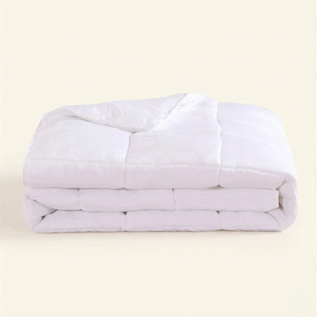 Folded white comforter on a beige background