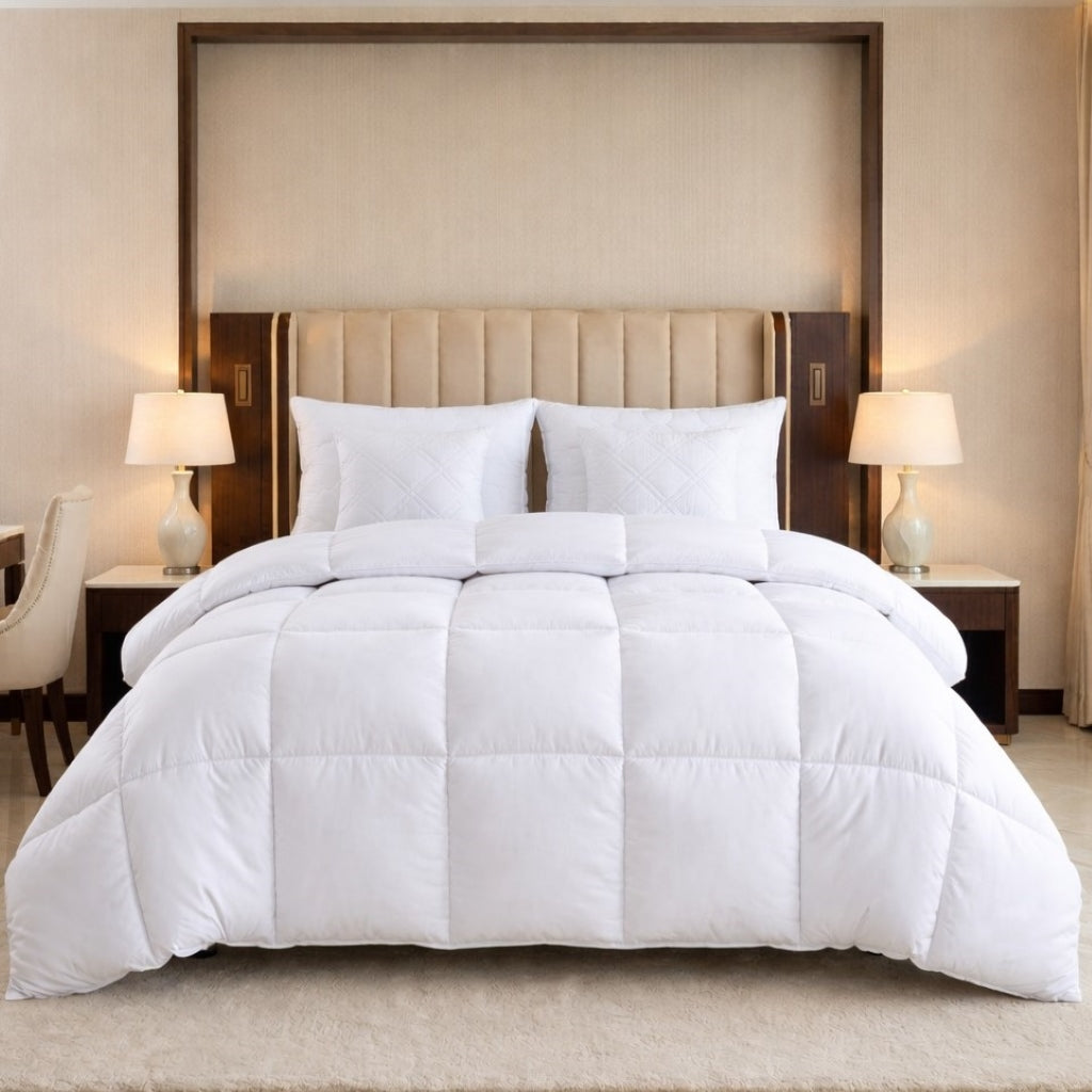White comforter set on a bed in a bedroom with lamps and headboard.