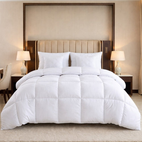 White comforter set on a bed in a bedroom with lamps and headboard.