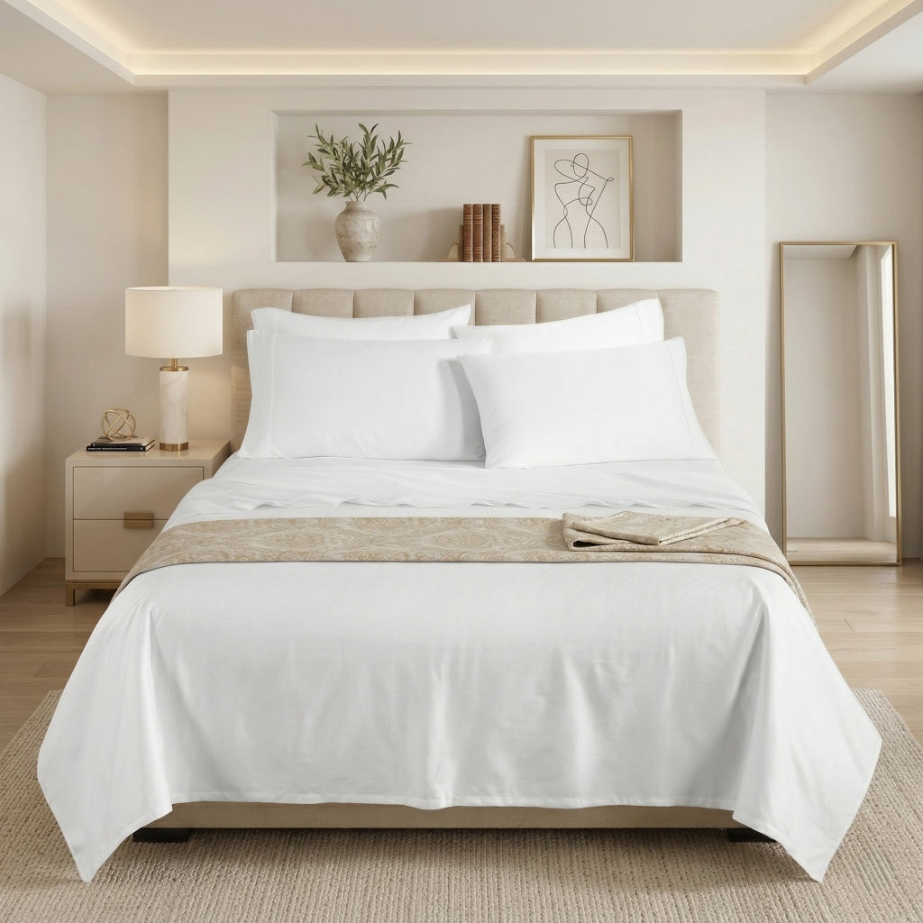 Neatly made bed with white bedding in a modern bedroom setting.