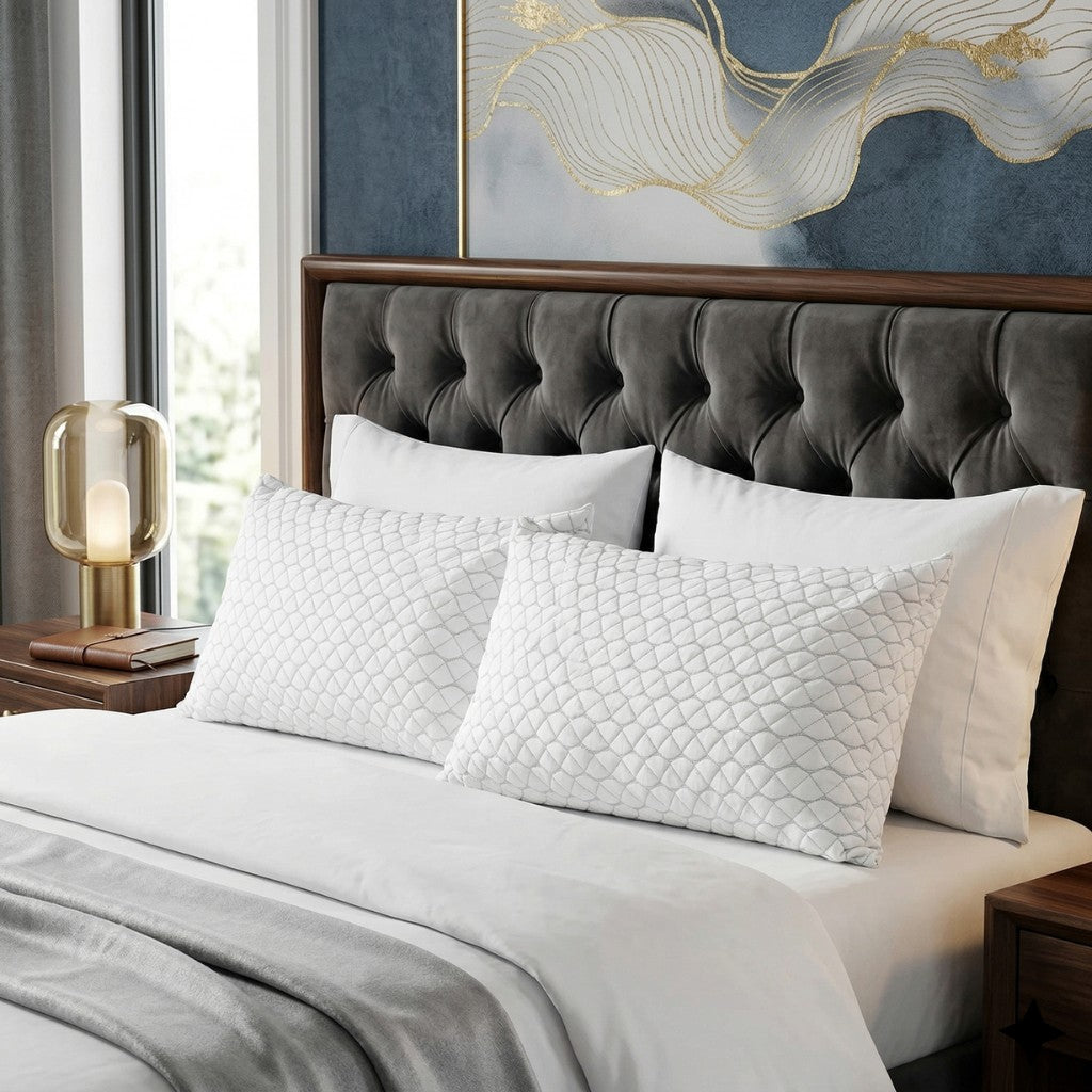 Bedroom with a tufted headboard, white   Adjustable pillows, and decorative wall art.
