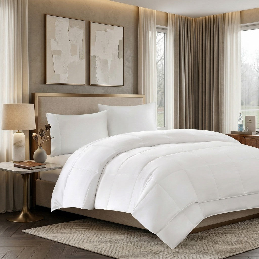 Neatly made bed with white bedding and comforter in a stylish bedroom setting.