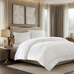 Neatly made bed with white bedding and comforter in a stylish bedroom setting.