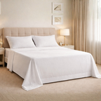 Neatly made bed with white bedding set in a bedroom setting.