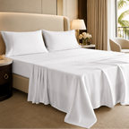 Neatly made bed with white bedding in a modern bedroom setting.
