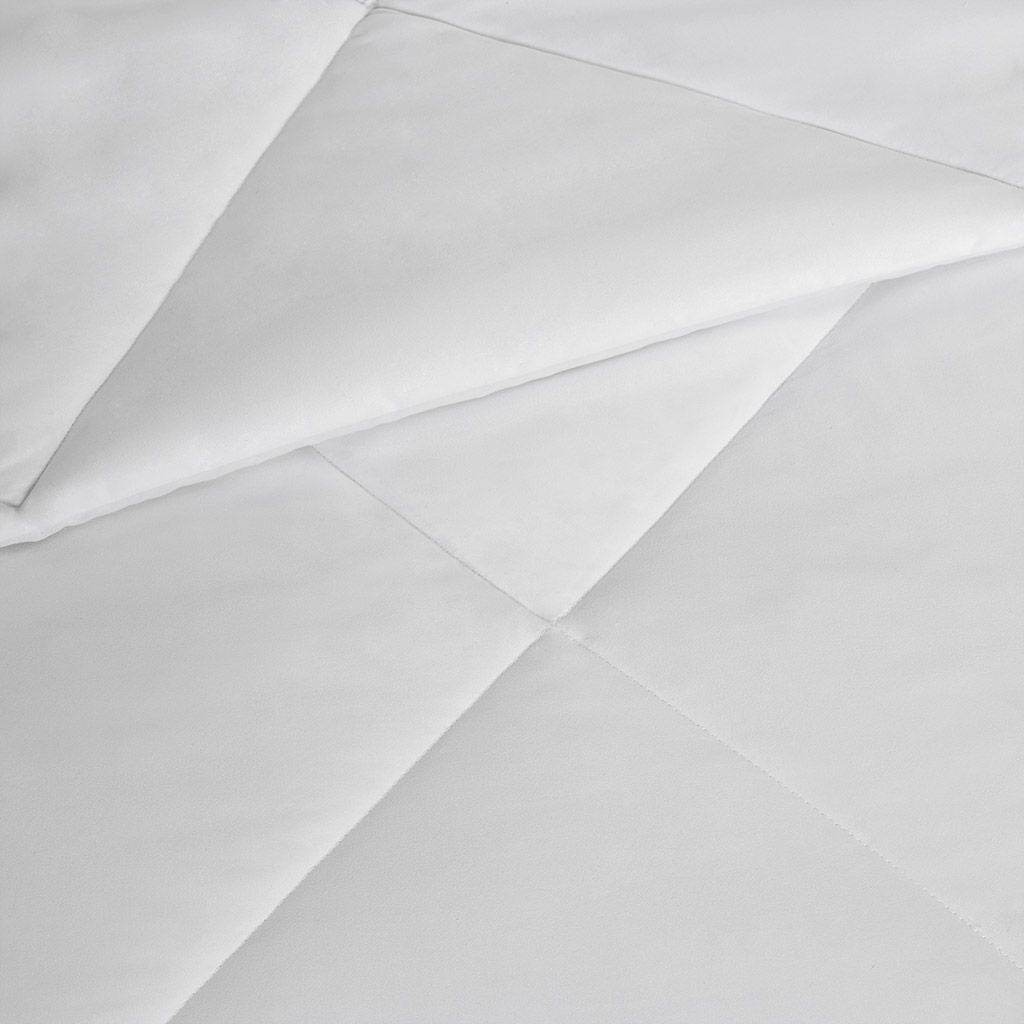 Close-up of white fabric with a subtle pattern on a light gray background