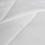 Close-up of white fabric with a subtle pattern on a light gray background