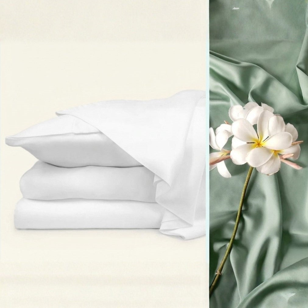 Stack of white sheets on a light beige background with green fabric and a white flower on a green background.